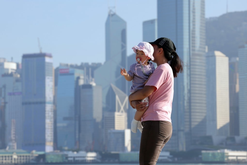 A mother carries her child at the West Kowloon Art Park on October 25. This year’s policy address included several measures aimed at raising the city’s birth rate, including a cash payment for each child born. Photo: Jelly Tse