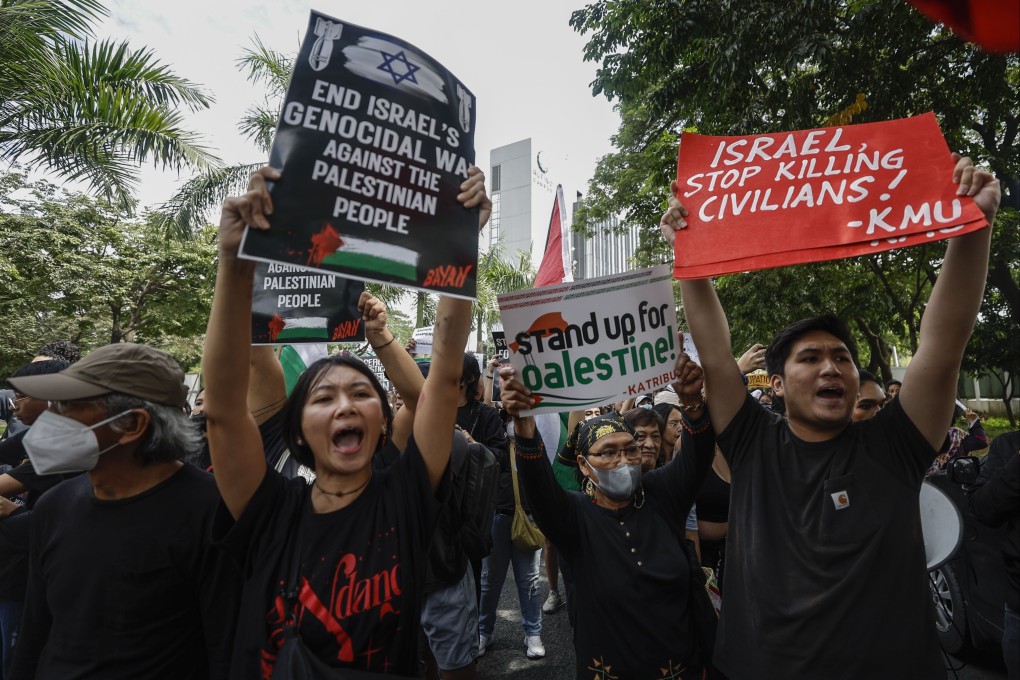 Protesters carry placards at a rally in support of the Palestinian people in Taguig City, Metro Manila, on Tuesday. Photo: EPA-EFE
