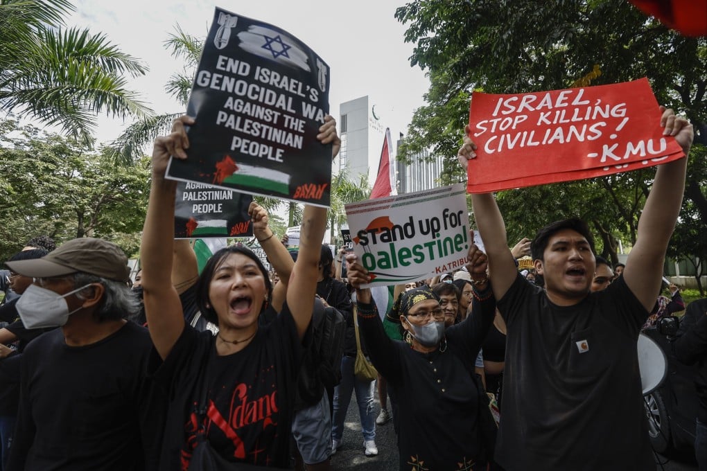 Protesters carry placards at a rally in support of the Palestinian people in Taguig City, Metro Manila, on Tuesday. Photo: EPA-EFE