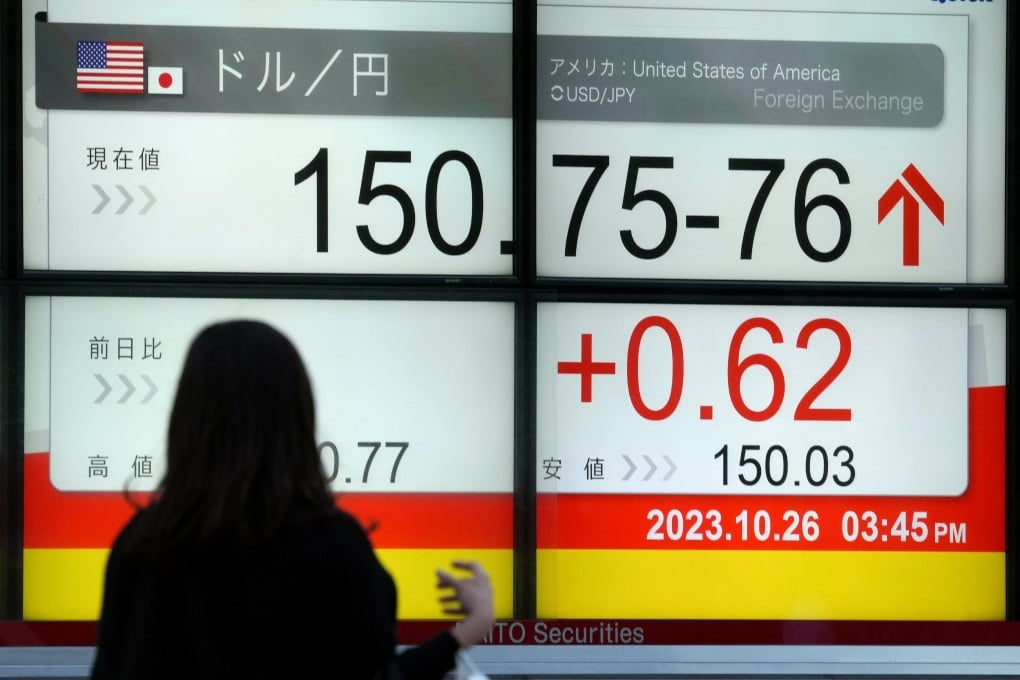 A pedestrian views a display showing the exchange rate between the Japanese yen and US dollar in Tokyo on October 26. The continued weakness of the yen is raising fears among some observers that, if left unchecked, other Asian economies might respond by weakening their currencies and starting a race to the bottom. Photo: EPA-EFE