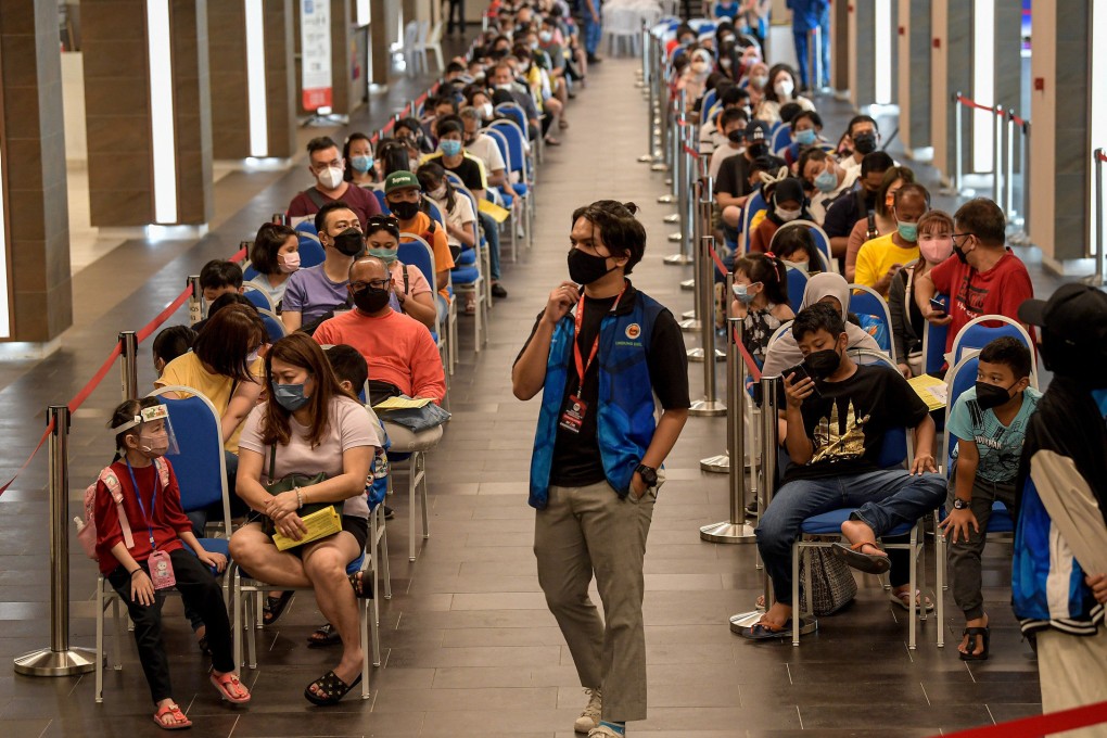 Children who are accompanied by their parents and guardians wait to be vaccinated against coronavirus at the Axiata Arena Vaccination Center in February 2022. Photo: Bernama/dpa