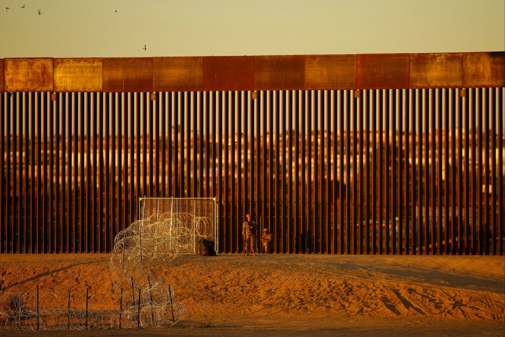Members of the Texas National Guard stand guard at a wire fence deployed to prevent migrants from crossing into the United States at the US-Mexico border, seen from Ciudad Juarez, Mexico on October 22. Photo: Reuters