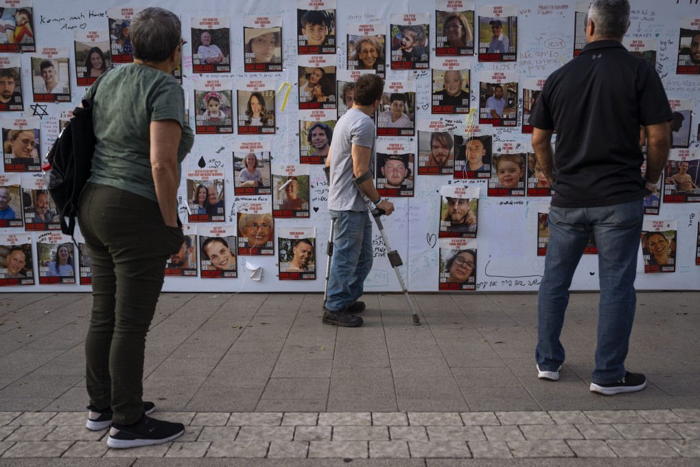 People look at photographs of hostages, mostly Israeli civilians who were abducted during the October 7 Hamas attack, in Tel Aviv, Israel on Monday. Photo: AP