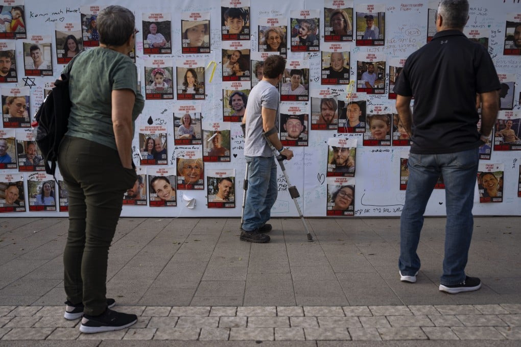 People look at photographs of hostages, mostly Israeli civilians who were abducted during the October 7 Hamas attack, in Tel Aviv, Israel on Monday. Photo: AP