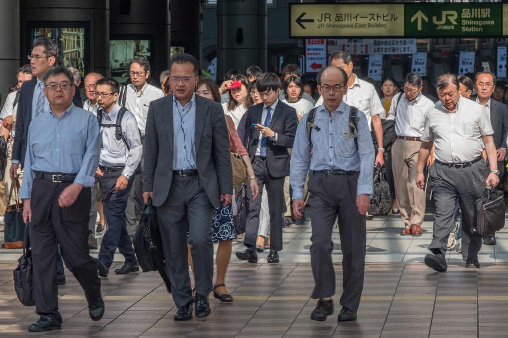Japanese white-collar workers at a Tokyo train station. A total of 2,968 people in Japan died from karoshi last year, up from 1,935 in 2021. Photo: Shutterstock