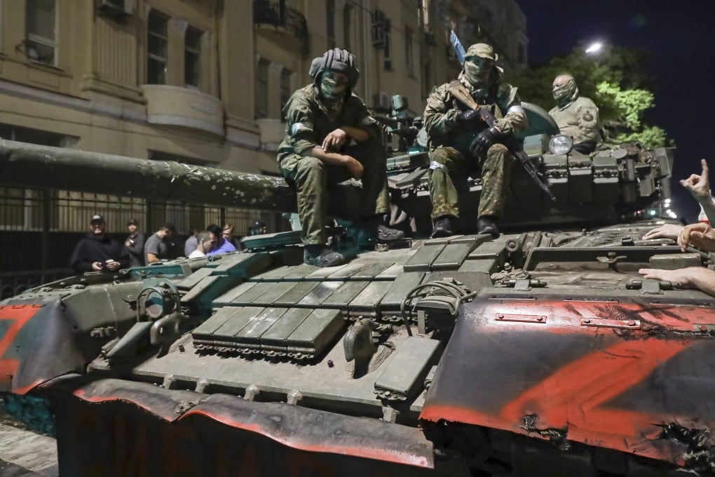 Membes of the Wagner Group military company sit atop of a tank. Photo: AP