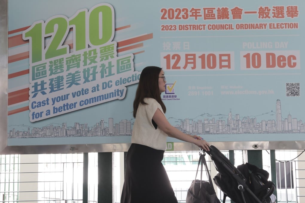 A pedestrian passes a large promotional poster for the 2023 district council elections, at Tsim Sha Tsui Pier on November 1. Centrists and the opposition have been all but frozen out of the upcoming election, leading to fears of reduced political diversity and representation. Photo: Jelly Tse