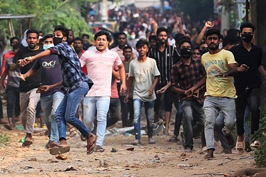 Garment workers clash with police personnel during a rally, demanding a near-tripling of their wages on Sunday. Photo: AFP