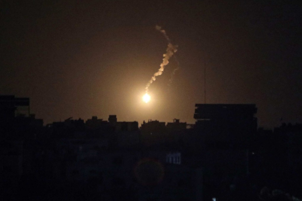 A flares lights the sky moments before an Israeli air strike on Gaza City. Photo: AFP