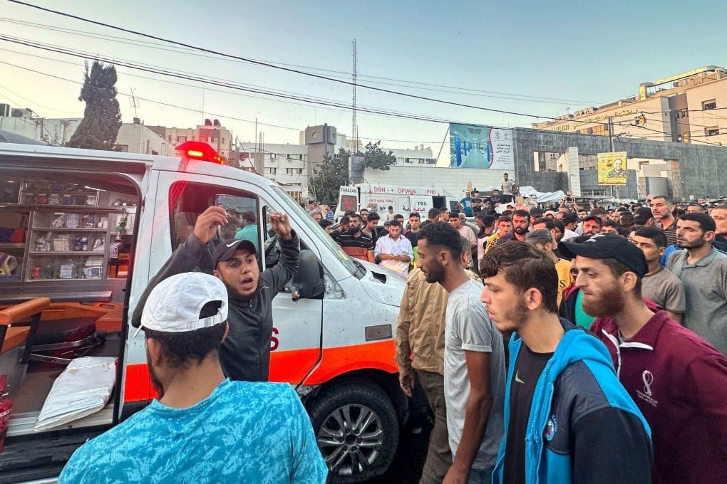 People gather around an ambulance damaged in a reported Israeli strike in front of al-Shifa hospital in Gaza City on Friday. Photo: AFP