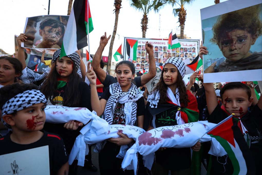 Palestinian children in the city of Ramallah hold posters during a protest in solidarity with children in the Gaza Strip on Saturday. Photo: AFP
