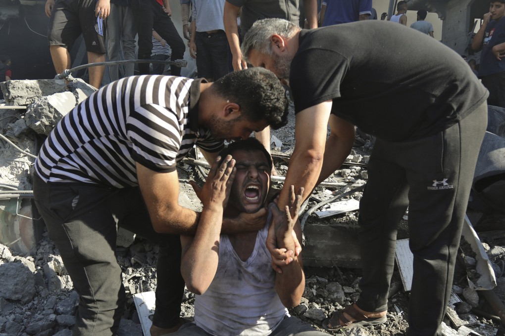 Palestinians comfort a crying man after losing relatives under the rubble of a destroyed house following an Israeli airstrike in Gaza City. Photo: AP