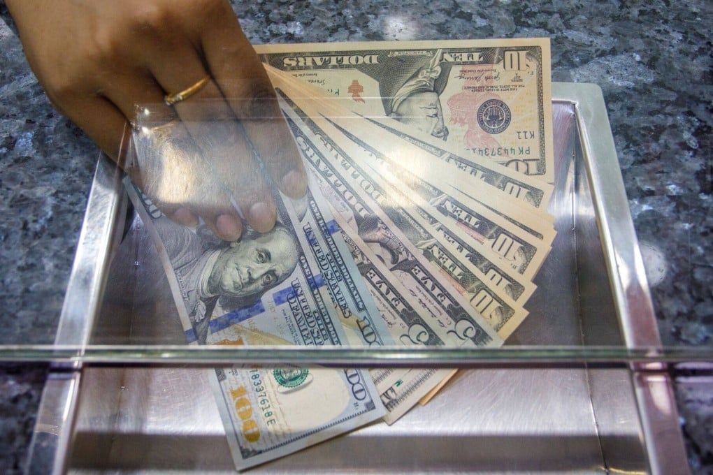 US dollar banknotes. At one point, Zeng passed a KLM agent her passport along with at least US$50 concealed underneath it. She asked in Mandarin for the agent to “help her”, the court heard. Photo: Bloomberg