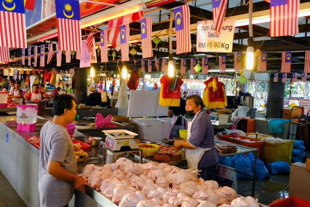 A customer and a chicken vendor at a wet market in Shah Alam, Malaysia. Photo: Bloomberg