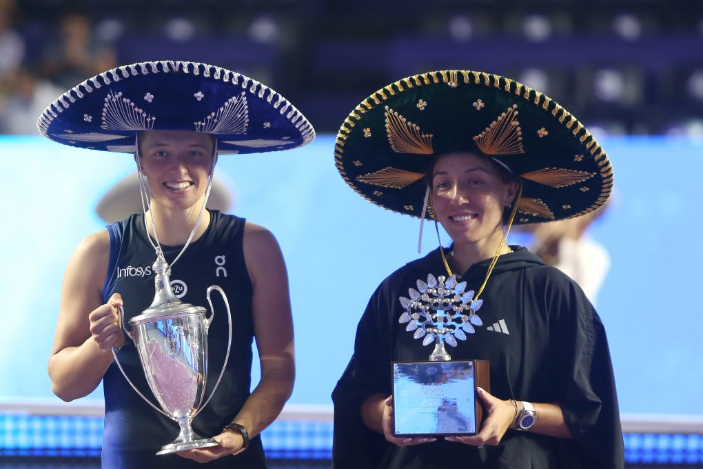 Iga Swiatek of Poland (left) holds the trophy after Jessica Pegula at the WTA Finals in Cancun. Photo: EPA-EFE
