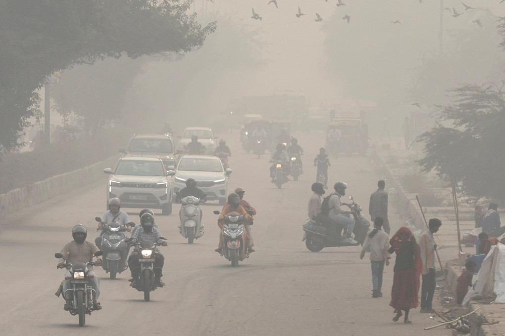 People and vehicles are seen on a road amid the morning smog in New Delhi, India, on Wednesday. Photo: Reuters