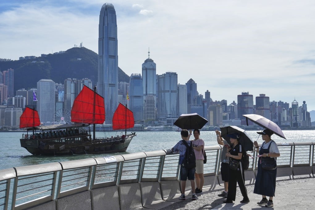 Tourists take pictures and hang around along the Tsim Sha Tsui Promenade. Photo: Elson Li
