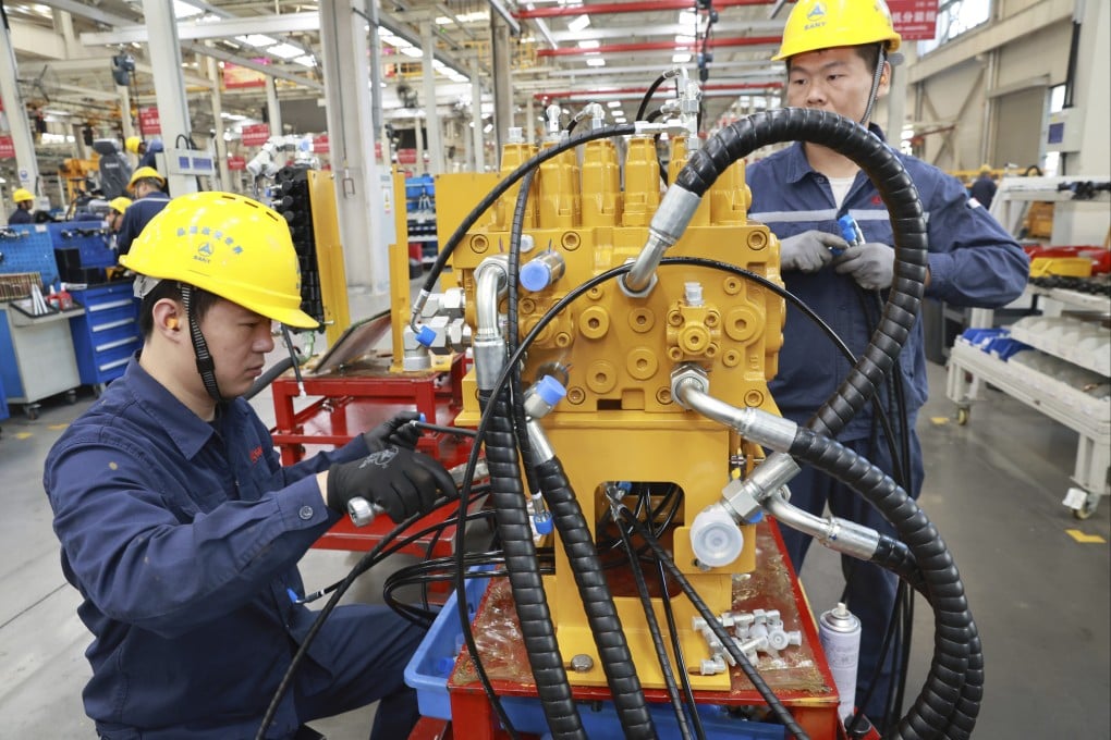 Workers assemble mini excavators in a heavy machinery factory in Suzhou, Jiangsu province, on October 23. Photo: AP