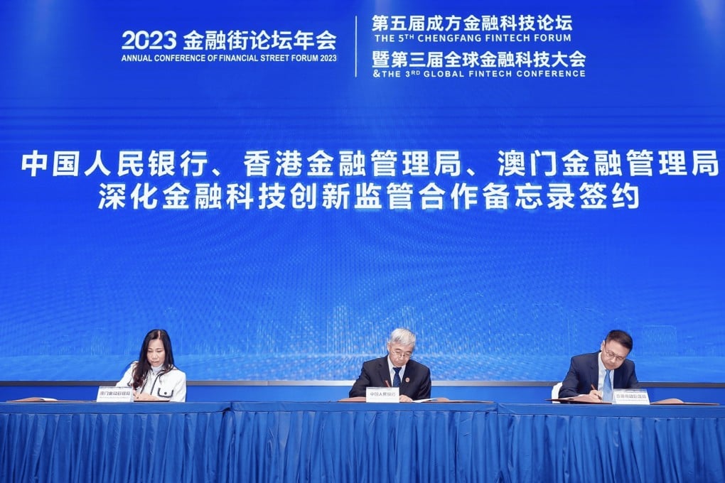 (From left) Henrietta Lau Hang-kun, executive director of the Monetary Authority of Macau, Zhang Qingsong, deputy governor of the People’s Bank of China, and Raymond Chan, executive director for banking supervision at the Hong Kong Monetary Authority, sign an MOU on deepening fintech innovation supervisory cooperation in the Greater Bay Area, in Beijing on Wednesday. Photo: HKMA