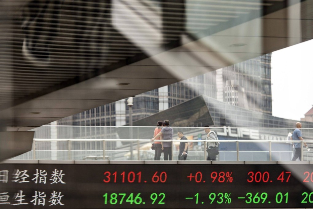 Pedestrians along an elevated walkway as an electronic ticker displays stock figures in Pudong’s Lujiazui Financial District in Shanghai, China. Photo: Bloomberg