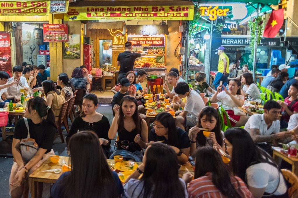 Groups of young Vietnamese people enjoy dinner at an open-air restaurant in Ho Chi Minh City. Vietnamese youth are starting to question the purpose of work in an economy where spoils are increasingly out of reach of the young. Photo: Shutterstock