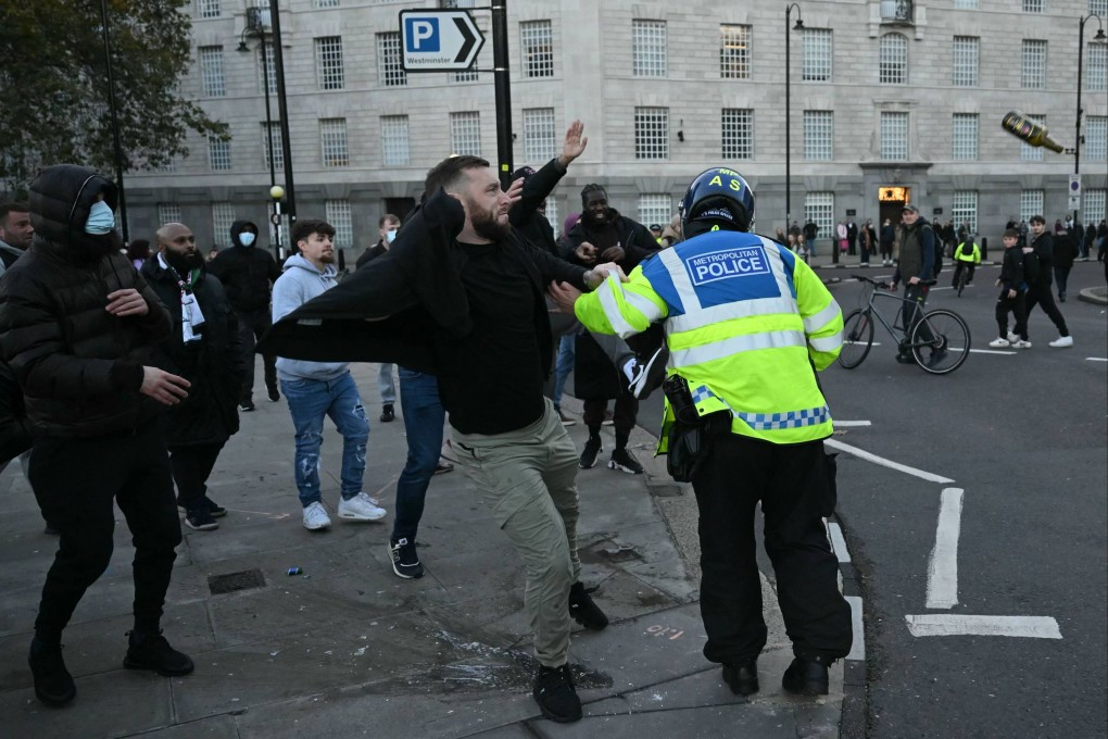 A police officer separates groups as bottles are thrown, close to the National March For Palestine in central London on Saturday. Photo: AFP