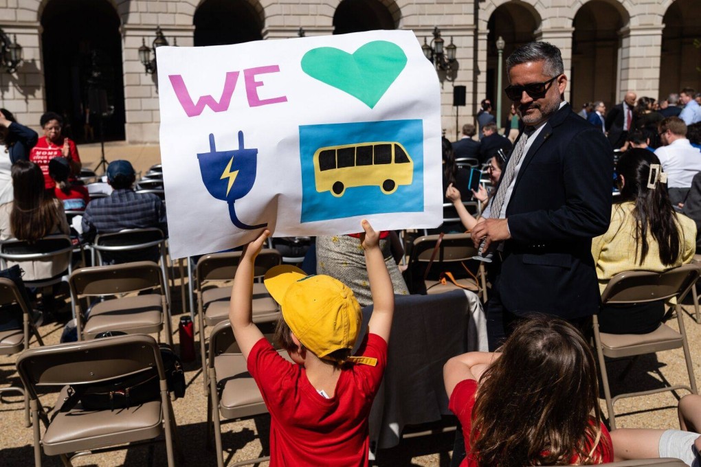 A young EV supporter holds up a poster at a Washington news conference on April 12. Currently, at least nine US states are pivoting towards EVs and planning to ban the sale of new combustion engine cars after 2035, with several other states considering joining them.  Photo: Bloomberg