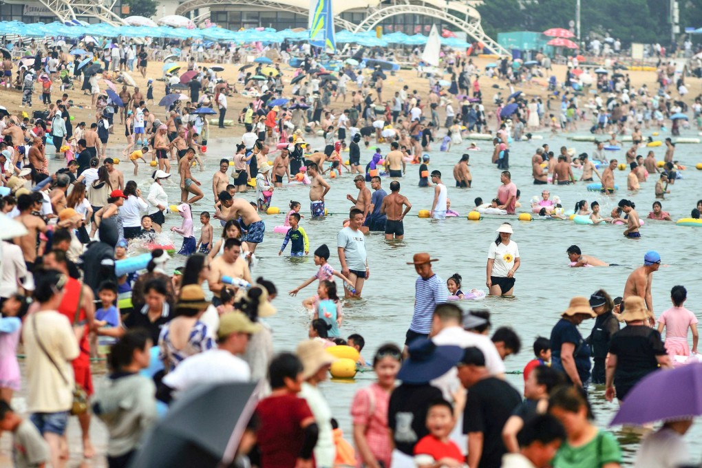 People cool off on a beach amid hot weather in Qingdao, in China’s eastern Shandong province in July. James Hansen, a former top Nasa scientist, has warned that the world’s average temperature will surpass the 1.5-degree threshold within the 2020s. Photo: AFP