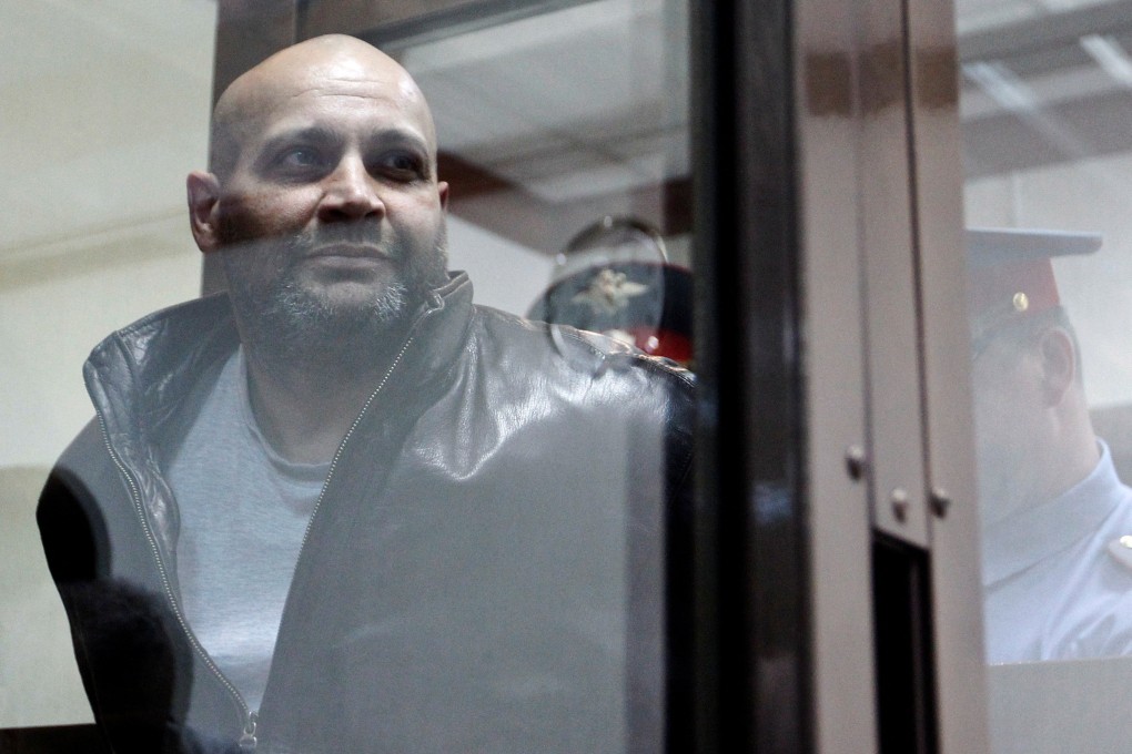 Sergei Khadzhikurbanov is escorted into a court hearing in Moscow in 2013.  Despite being convicted of murder, he has been pardoned, having fought in Ukraine. Photo: Reuters