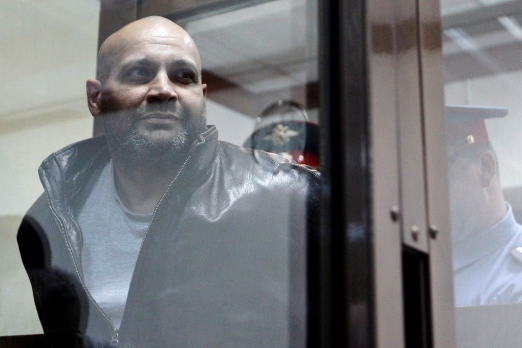 Sergei Khadzhikurbanov is escorted into a court hearing in Moscow in 2013. Despite being convicted of murder, he has been pardoned, having fought in Ukraine. Photo: Reuters