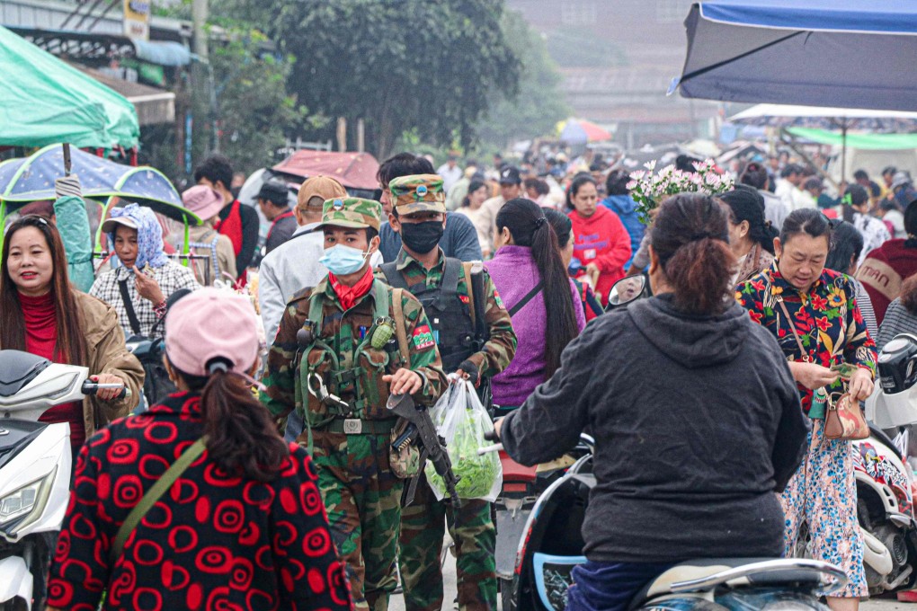 Fighters of the ethnic rebel group Ta’ang National Liberation Army walk down a street market in the town of Namhkam in northern Shan state on Friday. Photo: AFP