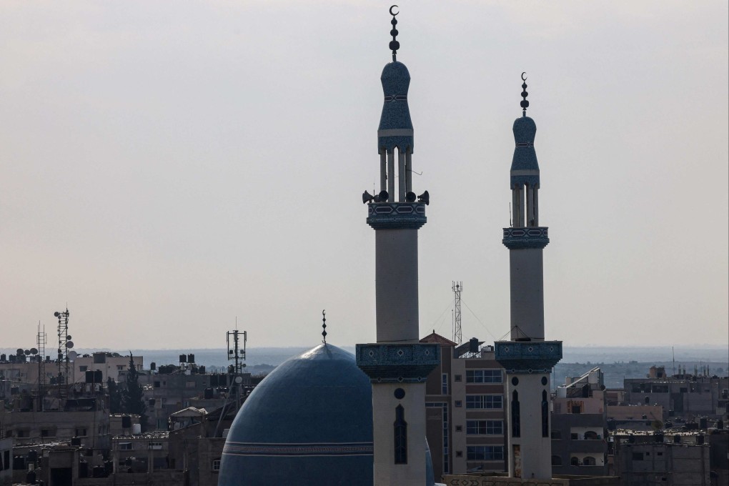 An antenna of a communications tower that relays phone and internet signals is pictured between the minarets of a mosque in Rafah, in the southern Gaza Strip in October. Photo: AFP