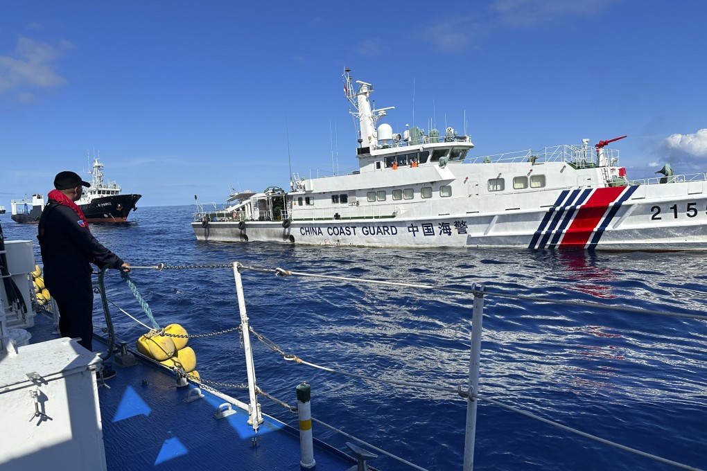 A Philippine Coast Guard member holds on a rubber fender as a Chinese coastguard vessel and suspected Chinese militia ship chases the Philippine coastguard vessel BRP Cabra at the disputed South China Sea on November 10. Photo: AP