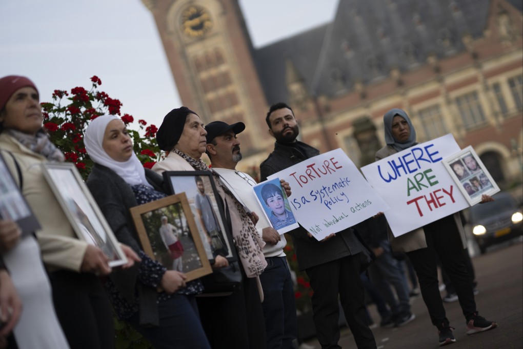 Demonstrators display pictures of people they say disappeared in Syria, outside the International Court of Justice in The Hague on Tuesday. Photo: AP