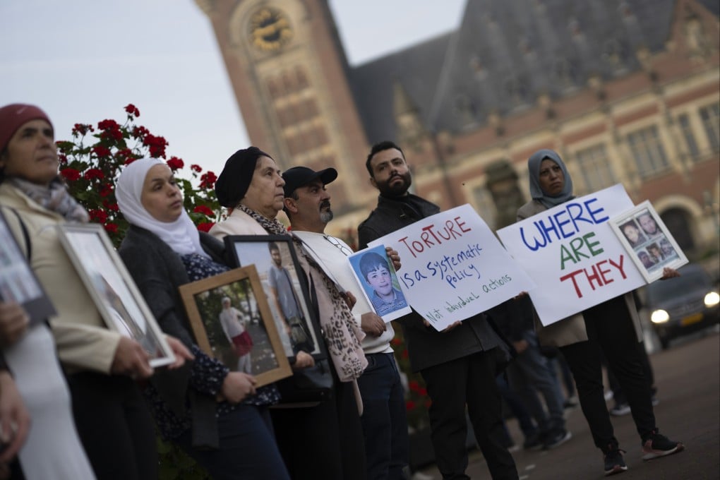 Demonstrators display pictures of people they say disappeared in Syria, outside the International Court of Justice in The Hague on Tuesday. Photo: AP