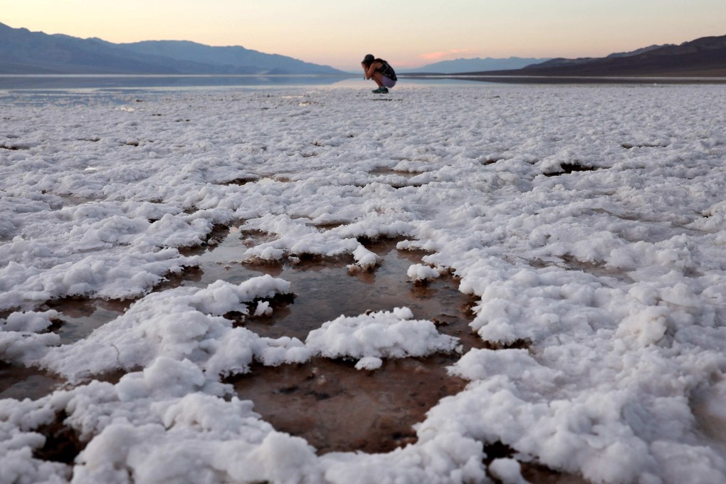 A visitor takes photos at the sprawling temporary lake at Badwater Basin salt flats in in Death Valley National Park, California, on October 21. Tropical Storm Hilary delivered a year’s worth of rain to Death Valley in a single day in August and flood damage forced the iconic desert park’s closure for eight weeks. Photo: Getty Images/AFP