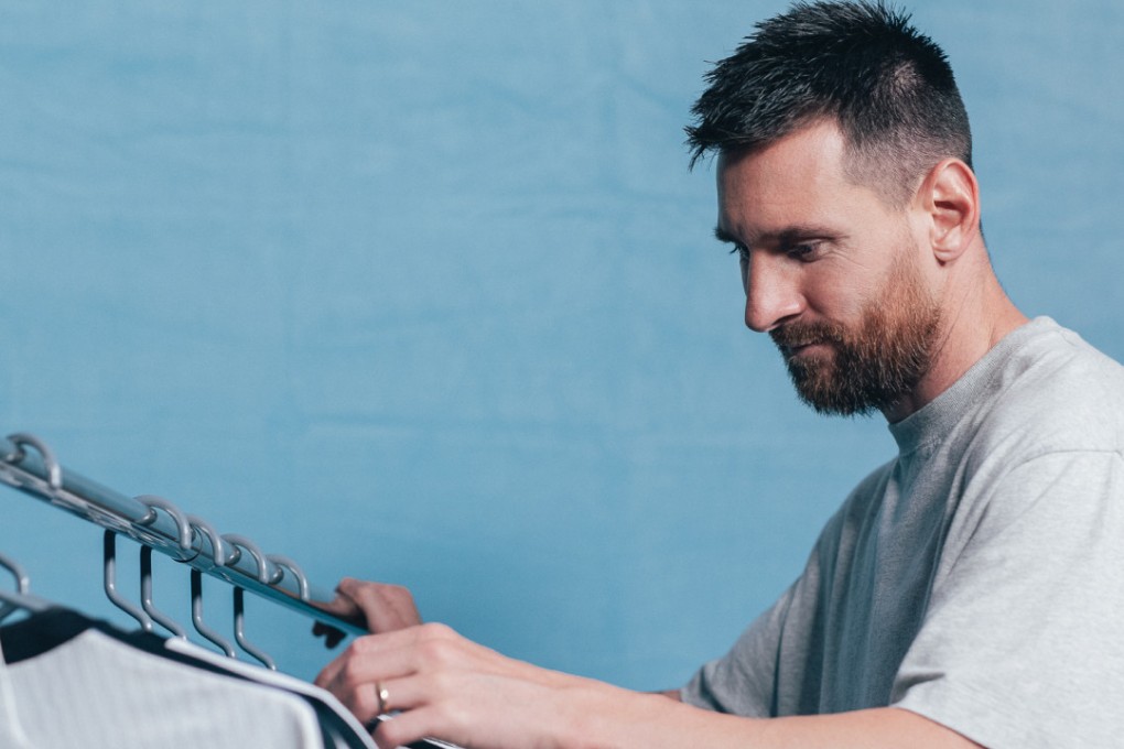 Lionel Messi and the set of six shirts that will be put up for auction. Photo: Sam Robles Photography