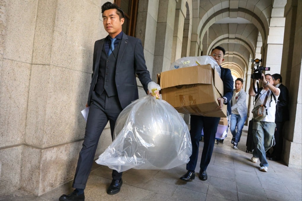Police carrying the evidence related to the case out of the court after the ruling was declared. Photo: Dickson Lee
