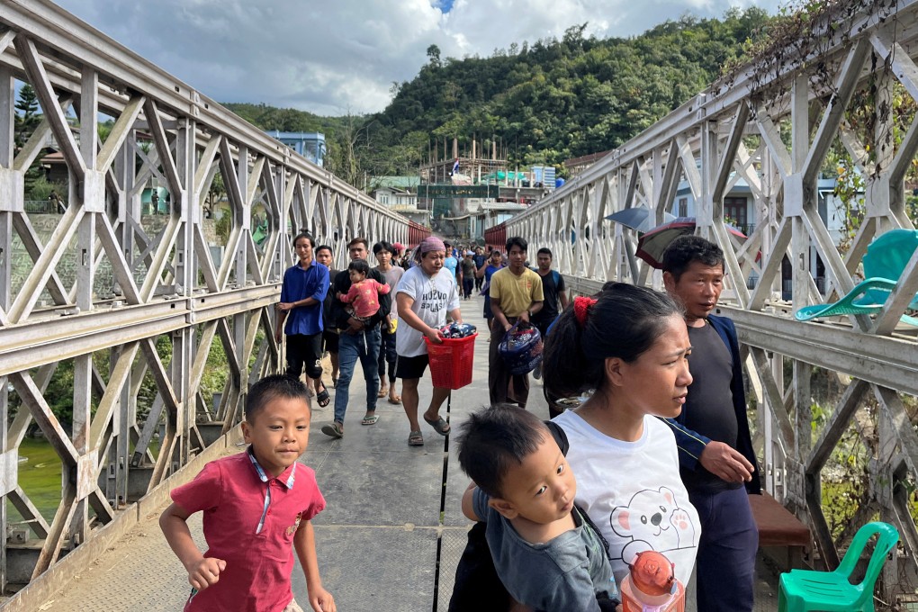 People who fled Myanmar carry their belongings across a bridge that connects Myanmar and India at the border village of Zokhawthar, Champhai district, in India’s northeastern state of Mizoram on November 15. Photo: Reuters