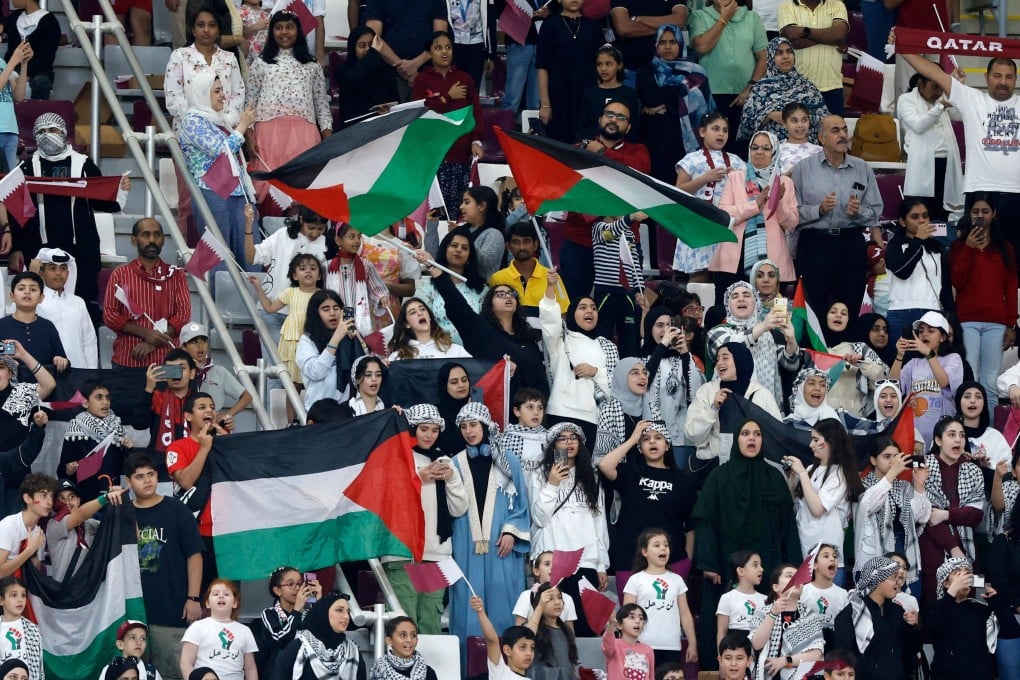 Fans wave the Palestinian flag during the World Cup Asian qualifier between Qatar and Afghanistan in Doha. Photo: AFP