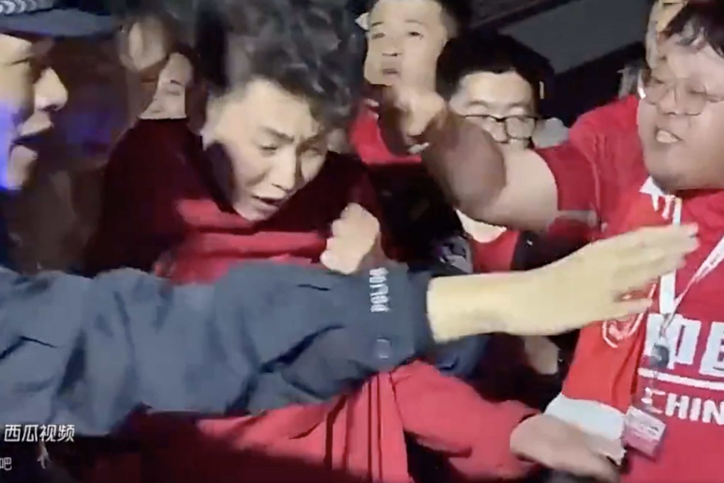 A fan who had been wearing a Son Heung-min jersey is escorted away by police as angry Chinese supporters surrounded him outside the stadium in Shenzhen. Photo: Weibo