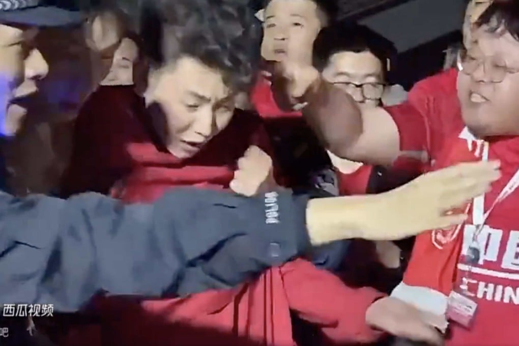 A fan who had been wearing a Son Heung-min jersey is escorted away by police as angry Chinese supporters surrounded him outside the stadium in Shenzhen. Photo: Weibo