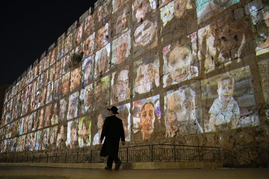 Photos of Israeli hostages being held by Hamas, projected on the walls of Jerusalem’s Old City. Photo: AP