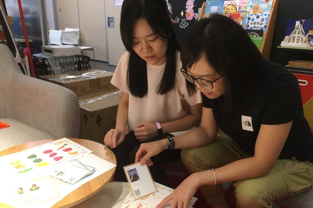 Chan Fung-mei (right), SLCO’s senior project coordinator, and Cheryl Tong Sum, a speech therapist, look over teaching material. Photo: Cindy Sui