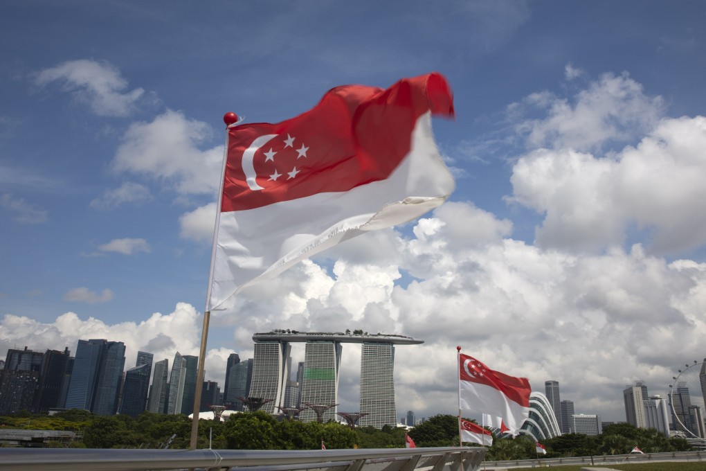Singapore national flags flutter over a view of the city state’s skyline. The government forecasts that growth may quicken next year. Photo: EPA-EFE