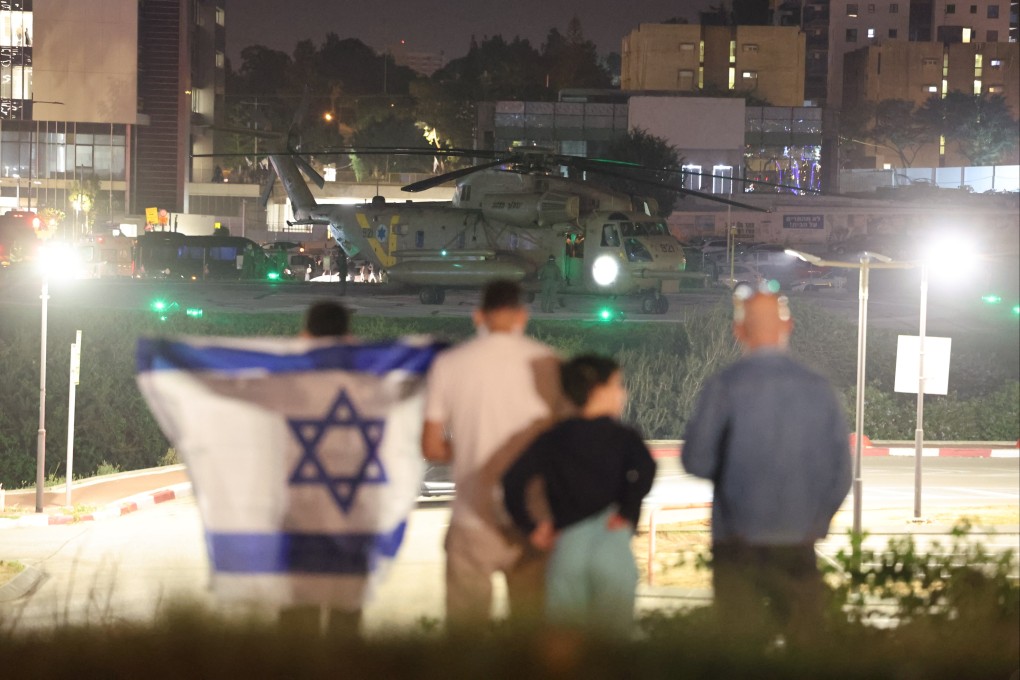 People with an Israeli flag look on as an Israeli army helicopter carrying children hostages held by Hamas in Gaza since October 7 landed near the Schneider Children’s Medical Centre in Petah Tikva, Israel, on Friday. Photo: EPA-EFE