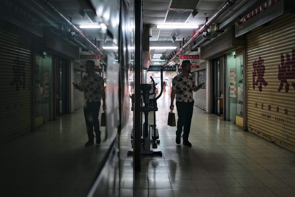 A shopper walks through Champagne Court in Tsim Sha Tsui on October 26. The 65-year-old shopping centre has been sold and earmarked for demolition, another example of Hong Kong retailers struggling to recover amid years of disruption and changing consumer patterns. Photo: Elson LI