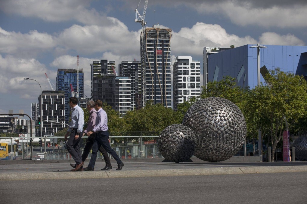 Pedestrians pass a residential buildings under construction in Brisbane, Australia, where prices have continued to rise despite higher interest rates. Photo: Bloomberg