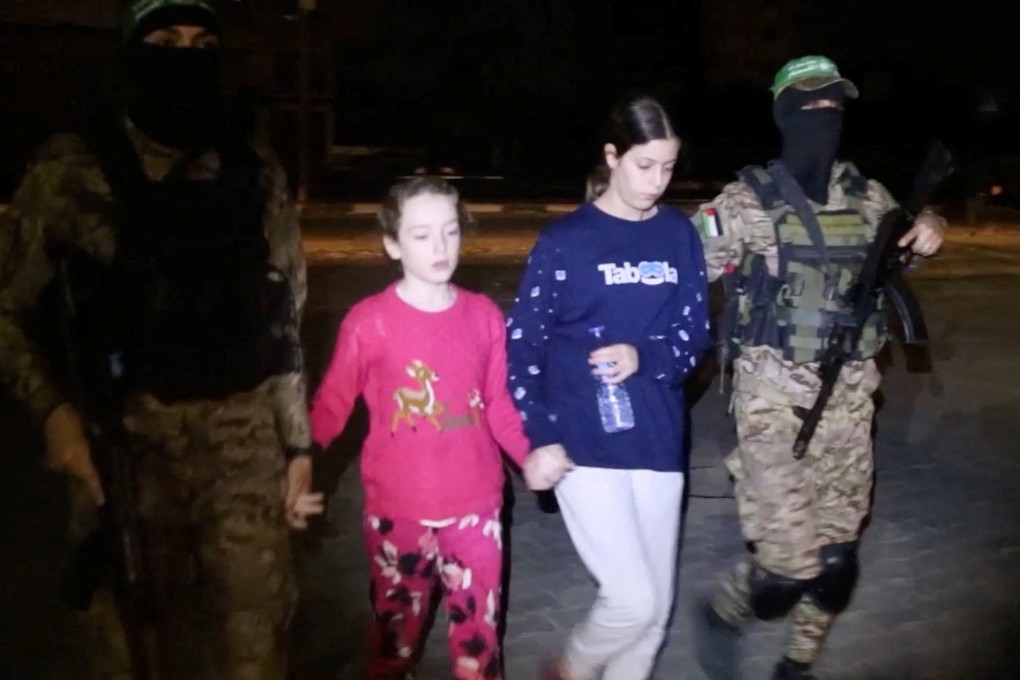 Hostages who abducted by Hamas gunmen during the October 7 attack on Israel are handed over to members of the International Committee of the Red Cross on Saturday. Photo: Hamas Military Wing via Reuters