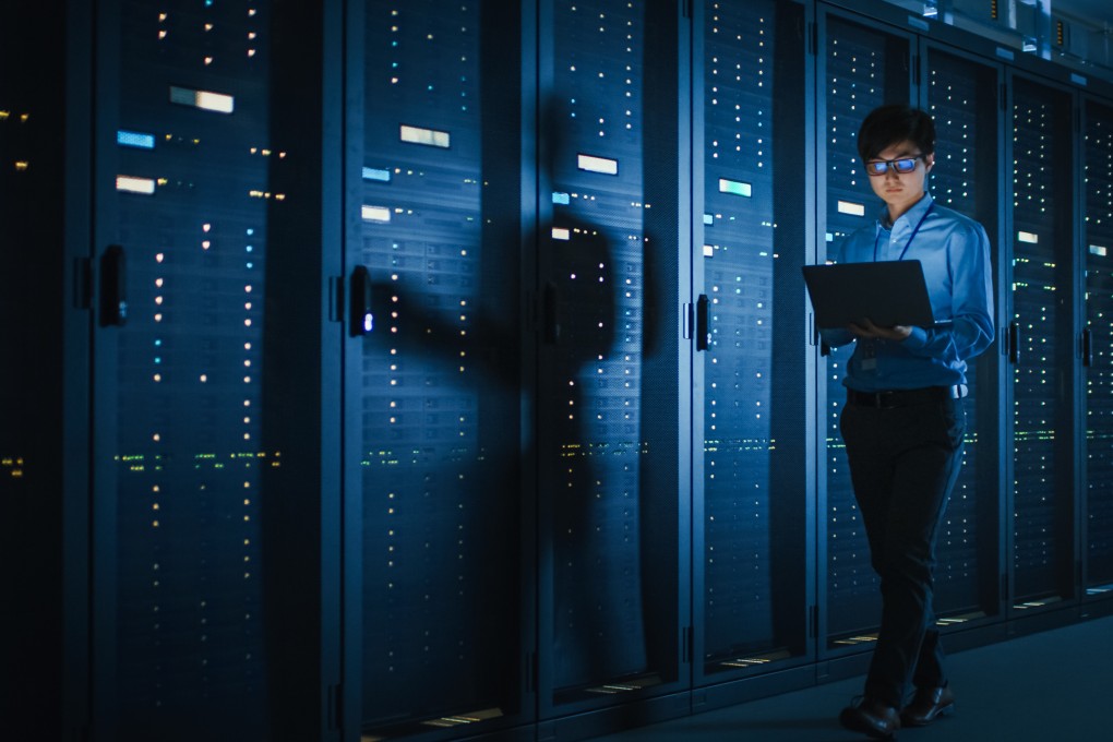 A technician inspects a row of server racks used for cloud computing. Photo: Shutterstock
